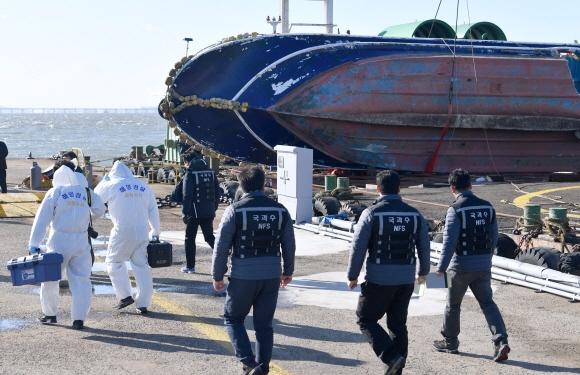 지난 3일 인천 영흥도 앞바다에서 급유선과 충돌해 전복된 낚시어선 선창 1호가 4일 인천 중구 인천해양경비안전서 전용 부두에 입항된 가운데 감식반의 선체조사를 위해 어선 쪽으로 이동하고 있다.  박지환 기자 popocar@seoul.co.kr