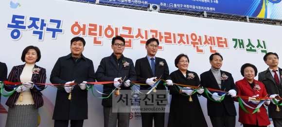 이창우(왼쪽 네 번째) 동작구청장이 지난 4일 서울 동작구 장승배기로에서 열린 ‘동작구 어린이 급식관리지원센터’ 개소식에서 테이프 커팅을 하고 있다.  손형준 기자 boltagoo@seoul.co.kr