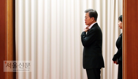 문재인 대통령이 6일 오전 청와대에서 방한 중인 비날리 이을드름 터키 총리를 기다리며 옷매무새를 고치고 있다. 2017. 12. 06  안주영 기자 jya@seoul.co.kr