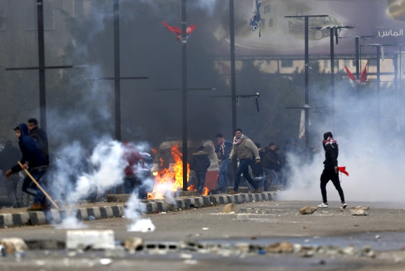 도널드 트럼프 미국 대통령의 ‘예루살렘 이스라엘 수도 공인’에 반발한 팔레스타인 시위대가 7일(현지시간) 요르단강 서안 나불루스에서 이스라엘군의 최루탄에 맞서 화염병을 던지며 격렬한 시위를 벌이고 있다. 나불루스 AP 연합뉴스