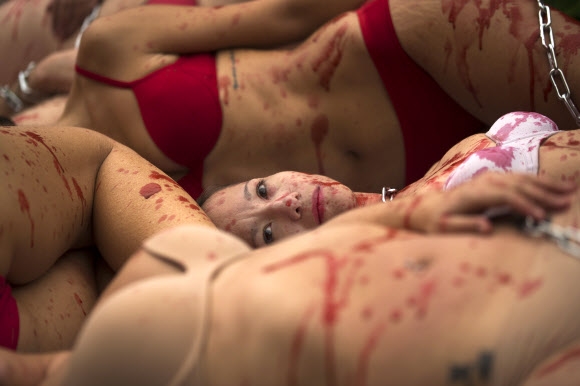 동물 보호 운동가들이 10일(현지시간) 스페인 마드리드에서 온몸에 가짜 피를 뿌리고 의류·패션업계의 동물 가죽 사용에 항의하는 퍼포먼스를 하고 있다. AP 연합뉴스