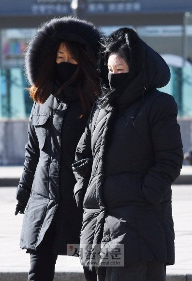 기온이 하루 종일 영하권에 머물며 매서운 추위가 닥친 11일 서울 종로구 광화문네거리에서 두꺼운 옷차림을 한 시민들이 차가운 겨울 바람을 맞으며 길을 걷고 있다. 2017. 12. 11 손형준 기자 boltagoo@seoul.co.kr