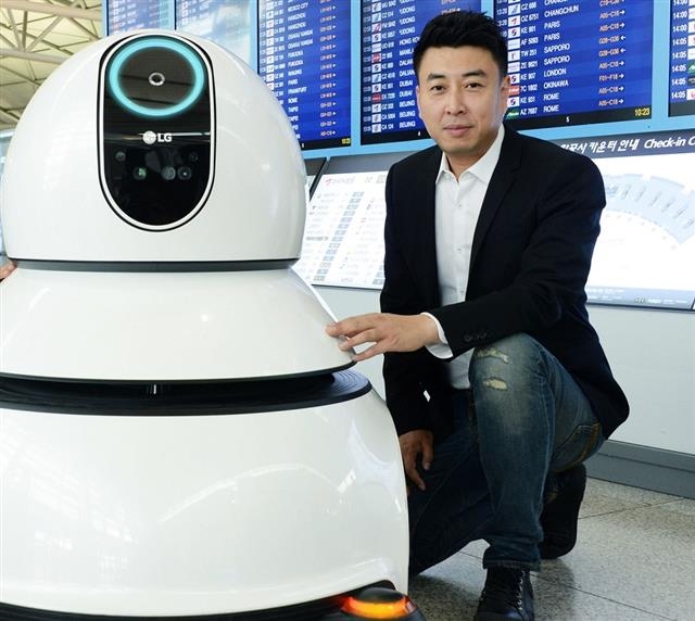 김성민 LG전자 책임연구원이 인천국제공항에서 자신이 디자인한 청소로봇과 포즈를 취하고 있다. LG전자 제공