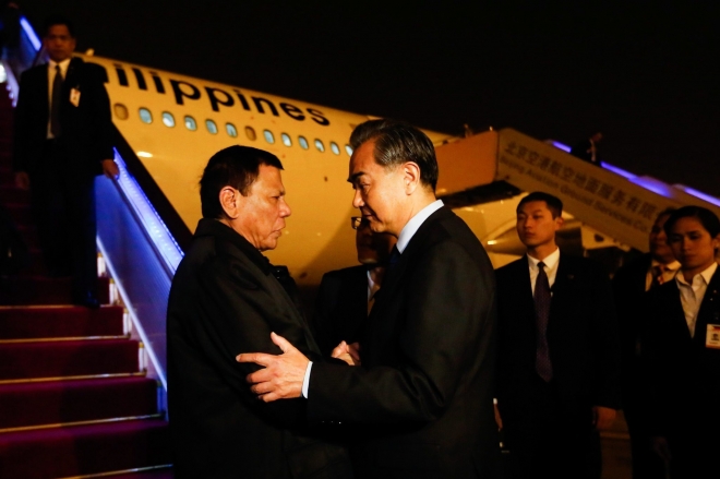 왕이(오른쪽) 중국 외교부장이 로드리고 두테르테 필리핀 대통령과 악수하면서 반가움의 표시로 팔을 만지는 장면. 출처:로스엔젤레스 타임스