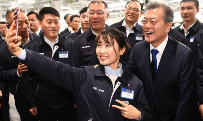 문재인 대통령이 중국 충칭 현대차공장의 중국인 직원과 활짝 웃으며 사진을 찍고 있다. 출처:환구시보