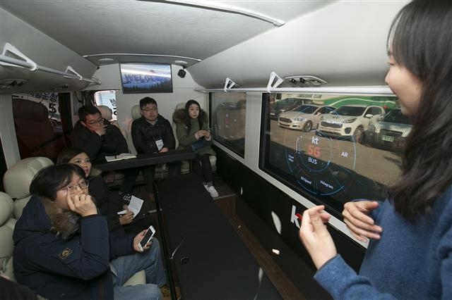 지난 19일 강릉 경포호 인근을 운행하는 5G 커넥티드 버스에서 KT 관계자가 차 창문에 구현된 AR 화면을 설명하고 있다.  KT 제공