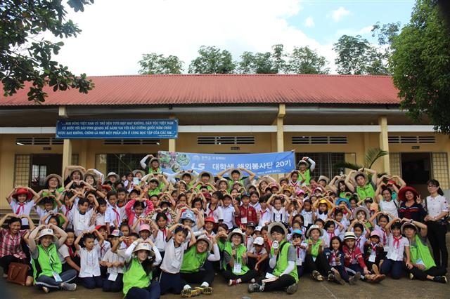 지난 8월 LS 대학생 해외봉사단 단원들이 베트남 동나이성에서 현지 초등학생들과 함께 하트를 그리며 기념사진을 찍고 있다 LS그룹 제공