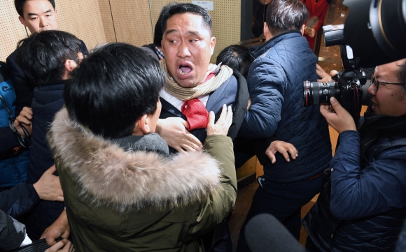 바른정당과의 통합에 반대하는 국민의당 당원이 31일 서울 여의도 당사에서 통합 반대를 외치다 당 관계자에게 제지당하고 있다. 강성남 선임기자 snk@seoul.co.kr