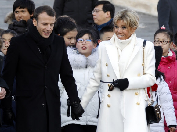 중국을 방문 중인 에마뉘엘 마크롱 프랑스 대통령과 부인 브리지트 여사가 9일 베이징 자금성을 둘러보고 있다. 39세로 프랑스 역대 최연소 대통령이 된 에마뉘엘 마크롱은 24세 연상의 부인과의 나이차로 화제가 되기도 했다.  AP 연합뉴스