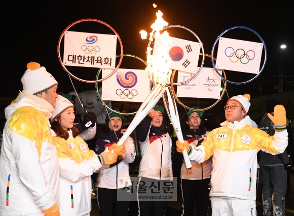 평창동계올림픽 성화의 서울 봉송 둘째 날인 14일 서울 송파구 잠실종합운동장에서 봉송 주자로 나선 전충렬(오른쪽) 대한체육회 사무총장과 여자아이스하키 국가대표 박종아(왼쪽 두 번째) 선수가 토치 키스를 하고 있다. 손형준 기자 boltagoo@seoul.co.kr