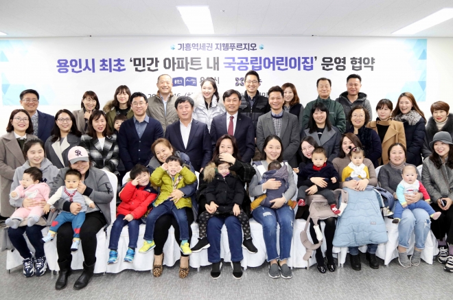 정찬민 용인시장(가운데줄 왼쪽에서 다섯번째)이 17일 기흥 지웰푸르지오 아파트 단지내 국공립어린이집 운영협약을 체결한후 주민들과 기념촬영하고 있다.용인시 제공