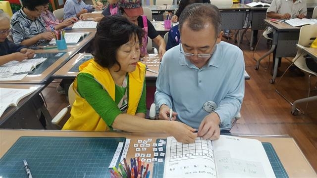 한 경증 치매 노인이 서울 성동구 치매지원센터의 기억키움학교에서 달력 만들기 활동을 하고 있다. 성동구 제공
