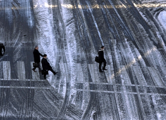 23일 일본 도쿄 도심에서 직장인들이 눈덮인 횡단보도를 건너며 출근길을 재촉하고 있다.  도쿄 AP 연합뉴스