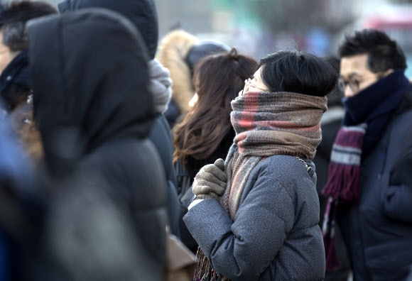 올 겨울들어 서울에 가장 늦은 기온을 기록한 24일 오전 세종로사거리에서 시민들이 신호를 기다리고 있다.  연합뉴스