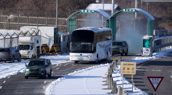 윤용복 북한 체육성 부국장을 단장으로 한 북측 선발대와 북한 여자 아이스하키 선수들이 탄 차량이 25일 오전 경기 파주시 남북출입국 경의선도로를 통해 입경하고 있다. 사진공동취재단