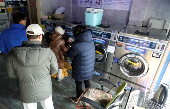 역대급 한파가 연일 계속되면서 세탁기 동파사고 등으로 인해 코인빨래방을 찾는 시민들이 늘고 있다. 28일 서울의 한 코인빨래방에서 시민들이 빨래를 돌리고 있다.  연합뉴스