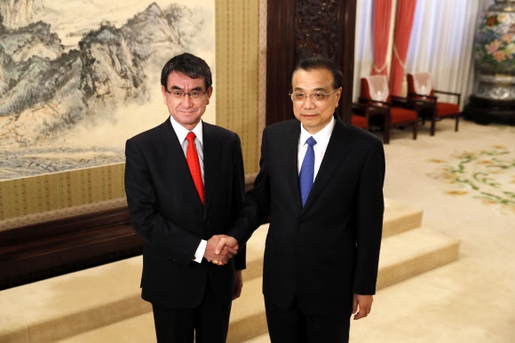 중국을 방문한 고노 다로(왼쪽) 일본 외무상이 지난 28일 베이징에서 리커창 중국 총리와 만나 악수하고 있다. 베이징 AP 연합뉴스