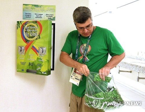 　2년 전 리우데자네이루올림픽 선수촌 직원이 무료 콘돔 자판기에 콘돔을 채워 넣고 있다. 　연합뉴스 자료사진 