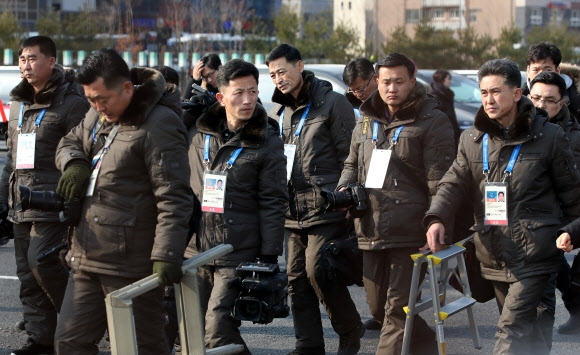 북한선수단의 공식 입촌식이 열린 8일 북한 기자들이 ‘은방울’ 상표가 달린 방한복을 나란히 차려입고 선수촌에 도착하고 있다. 강릉 연합뉴스
