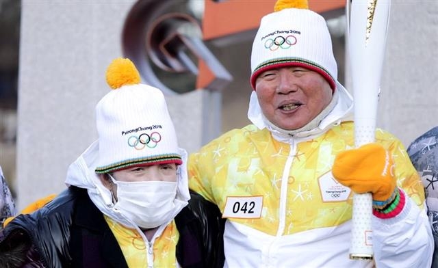 손진익(오른쪽) 회장이 평창동계올림픽 개막 이틀을 앞둔 지난 7일 부인 김종희씨와 나란히 성화를 봉송하고 있다. 엘베스트 그룹 제공