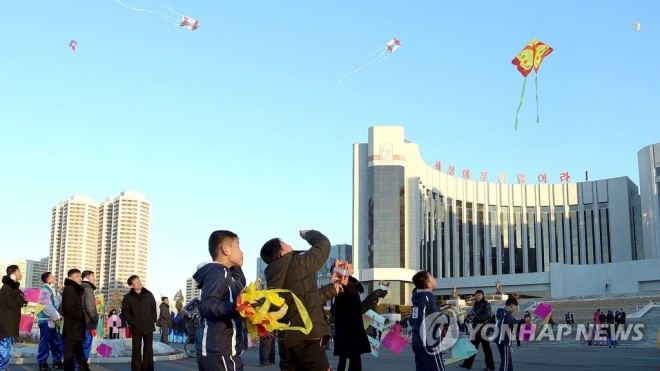 지난해 설명절인 1월 28일 북한 평양시 만경대구역 만경대학생소년궁전 앞에서 청소년들이 연을 하늘에 뛰으며 놀고 있는 모습. 연합뉴스