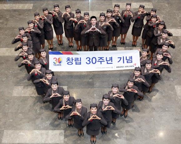 아시아나항공 신입 승무원들이 14일 서울 강서구 본사에서 창립 30돌을 자축하며 하트를 만들어 보이고 있다.  아시아나항공 제공