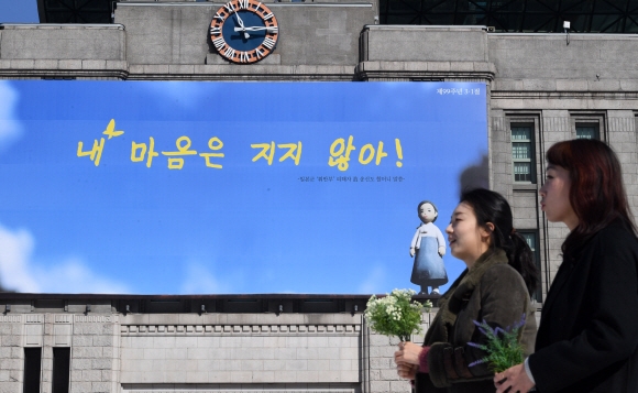 올해 99돌 3·1절을 앞두고 26일 서울광장 꿈새김판이 일본군 위안부 피해자 고 송신도 할머니의 외침인 ‘내 마음은 지지 않아!’로 바뀌어 있다. 일본에 살던 송 할머니는 1993년 일본 정부를 상대로 사죄와 배상청구 소송을 제기했고, 10년에 걸친 법정 다툼 끝에 패소했지만 결코 지지 않겠다는 굳은 의지와 신념이 담긴 말을 남겼다. 꿈새김판의 글씨는 또 다른 일본군 위안부 피해자인 이옥선 할머니가 썼다.  도준석 기자 pado@seoul.co.kr