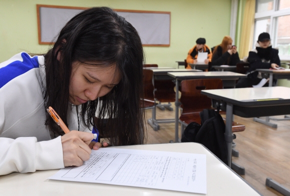 2018 대학수학능력시험이 치뤄진 뒤 서울의 한 고등학교에서 학생이 가채점 점수를 적고 있다.  도준석 기자 pado@seoul.co.kr