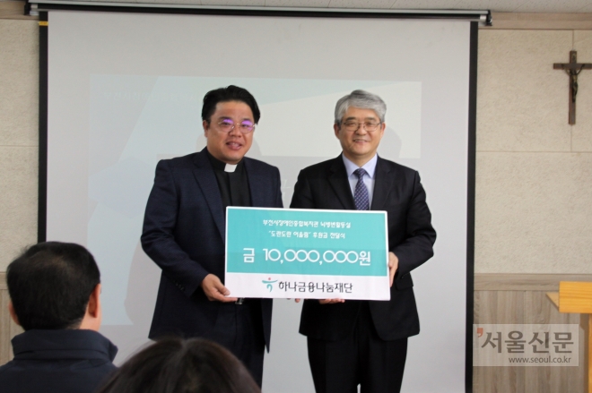 윤종웅(오른쪽) 하나금융나눔재단 이사가 김복기 부천시장애인종합복지관장에게 후원금을 전달하고 있다. 부천시 제공