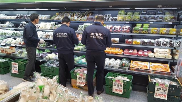 부산특사경 식품수사팀이 지난 6일 부산 연산동 거제시장 식육판매점 진열대에서 제품의 원산지 표시 등이 제대로 이뤄졌는지 꼼꼼히 살펴보고 있다. 수사팀은 이날 유통기한 및 축산물 표시 사항 위반 등의 여부를 확인해 시정 조치했다.  부산시 제공