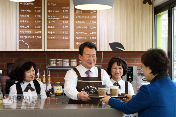 나진구 중랑구청장이 지난 7일 면목천변 녹지대에 최근 문을 연 실버 바리스타 카페 2호점에서 손님에게 커피를 건네주고 있다.  도준석 기자 pado@seoul.co.kr 