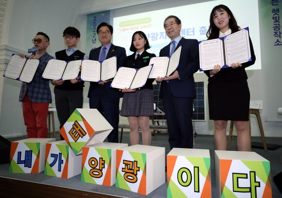 12일 서울시청 시민청에서 열린 서울에너지공사 태양광지원센터 출범식에서 박원순 (오른쪽 두 번째) 서울시장과 더불어민주당 우원식(네 번째) 원내대표가 학생들과 선언문을 발표한 후 기념촬영하고 있다.  연합뉴스