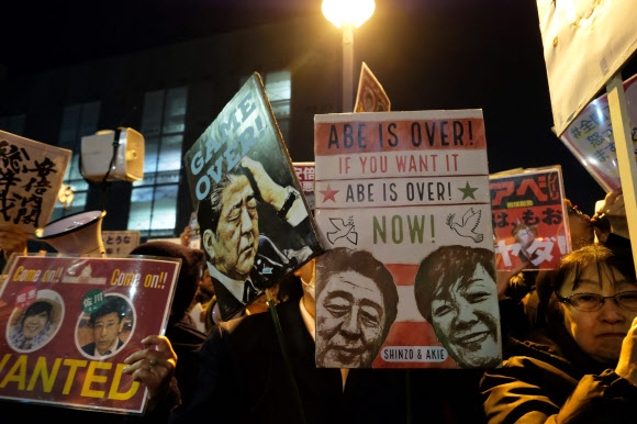 12일 도쿄 총리 관저 앞에 시민들이 모여 ‘아베 사퇴’를 요구하는 내용의 팻말을 들고 항의 집회를 하고 있다.  도쿄 AFP 연합뉴스