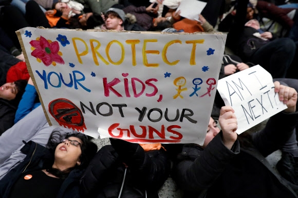 뉴욕 퀸스 집회에 참여한 학생들은 “총이 아니라 당신의 아이들을 지켜 주세요”, “다음은 나인가요”라고 적은 손팻말을 들고 바닥에 드러누워 시위를 했다. 뉴욕 로이터 연합뉴스
