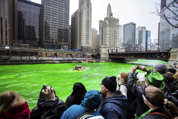 17일(현지시간) ‘성 패트릭의 날’을 맞아 미국 시카고 강이 초록색으로 염색되고 있다. 많은 시민들이 염색된 강을 구경하고 있다. AP 연합뉴스
