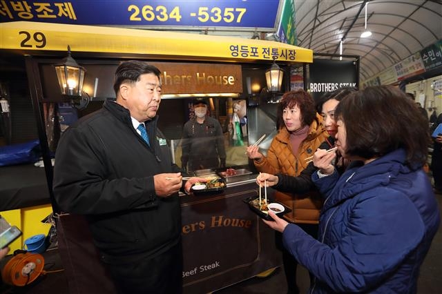 조길형(왼쪽) 영등포구청장이 지난 16일 영등포전통시장에 문을 연 야시장에서 스테이크를 먹으며 주민들과 대화를 나누고 있다. 영등포구 제공