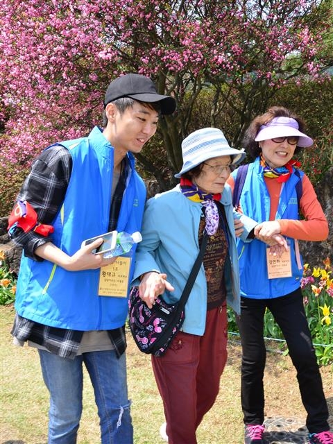 서울 중랑구 365 서포터스 봉사단원들이 거동이 불편한 지역 어르신의 봄나들이 활동을 돕고 있다.  중랑구 제공