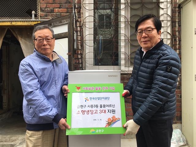 박복술(오른쪽) 서울 금천구 시흥3동 동장이 지난 20일 홀몸 어르신 가정을 찾아 한국산업단지공단에서 후원받은 소형냉장고 3대를 전달하는 기념식을 하고 있다. 금천구 제공