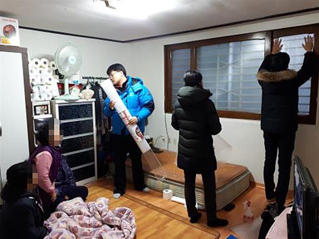 서울 광진구 구의3동 ‘청소년 마을 ECO 기자단’이 지난 1월 지역 내 독거노인 가정을 방문해 단열시트를 설치하고 있다. 광진구 제공