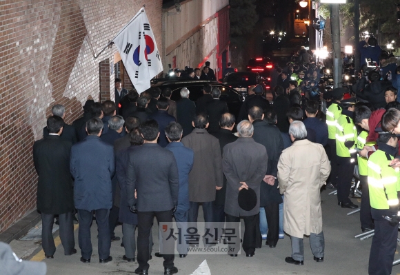 22일 밤늦게 구속된 이명박 전 대통령이 동부구치소로 향하는 모습을 자택 앞에서 측근들이 지켜보고 있다.  도준석 기자 pado@seoul.co.kr