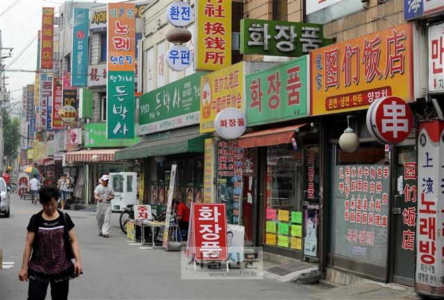 한 주민이 서울 구로구 가리봉동 우마길(연변거리)에 설치된 색색의 간판들 앞으로 걸어가고 있다. 서울신문 DB