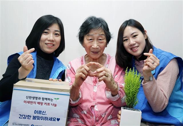 신한생명 직원들이 서울 구로구에 사는 독거노인 가정에 방문해 미세먼지 예방용품과 공기정화 화분을 전달하고 있다.  신한생명 제공