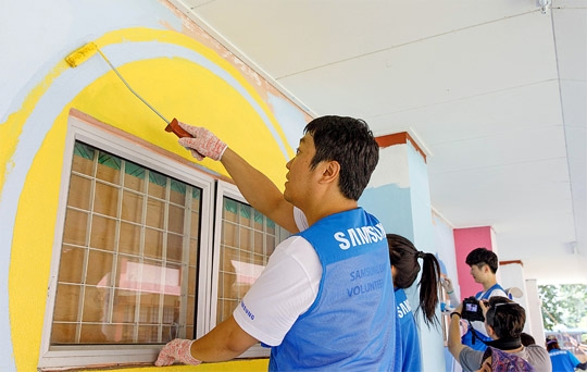 삼성전자 임직원들이 말레이시아 쿠알라룸푸르에 있는 현지 중학교 외벽에 벽화를 그리고 있다.