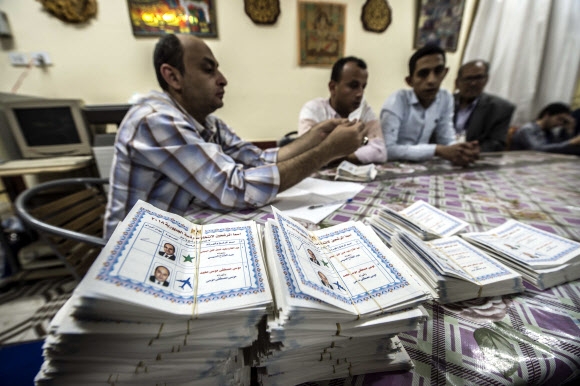 이집트 카이로의 대통령 선거 투표소 관계자가 28일(현지시간) 대선 투표용지를 확인하고 있다. 현지 언론들은 압둘팟타흐 시시 현 대통령이 재선에 성공할 것으로 관측했다. 카이로 EPA 연합뉴스