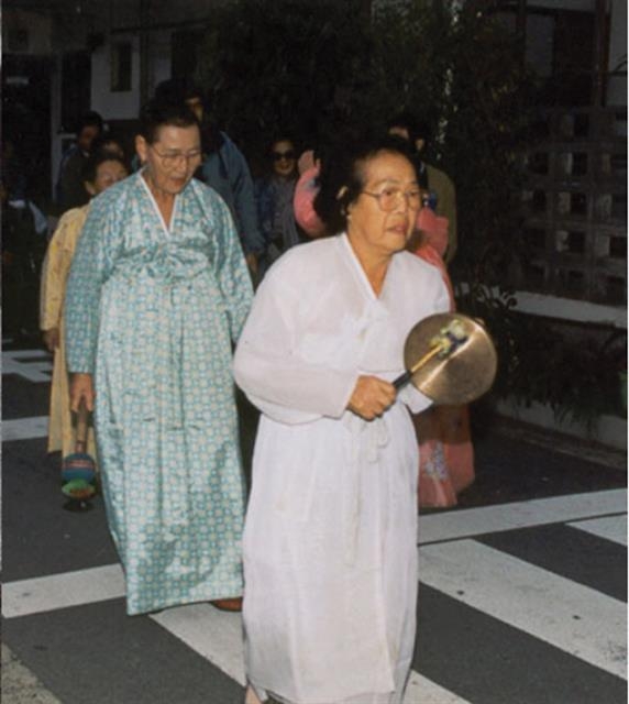 위안부 피해자 보상을 위한 일본 항의 방문에서 문옥주 할머니가 꽹과리를 치며 다른 피해자들과 함께 도보 행진을 하고 있다.  푸른역사 제공