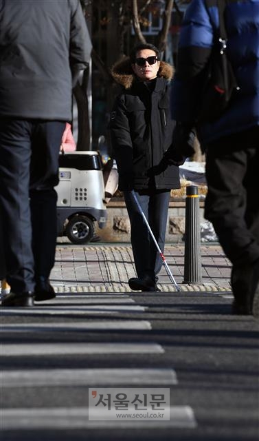 꽃샘추위로 기온이 뚝 떨어진 지난달 22일 시각장애인 체험에 나선 정원오 서울 성동구청장이 흰 지팡이로 바닥을 두드리며 횡단보도를 건너고 있다.  강성남 선임기자 snk@seoul.co.kr
