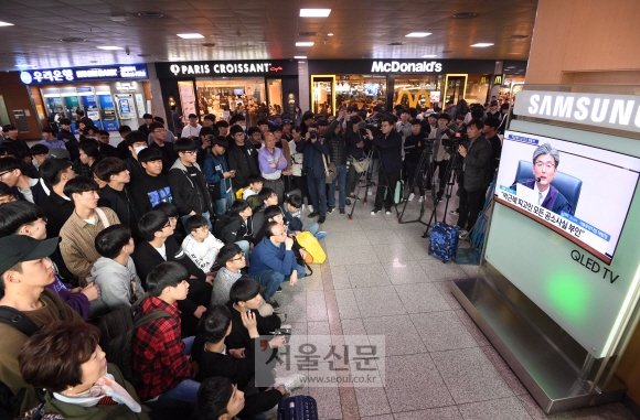 6일 오후 서울역 대합실에서 승객들이 박근혜 전 대통령의 1심 선고공판 생중계를 시청하고 있다. 이호정 전문기자 hojeong@seoul.co.kr