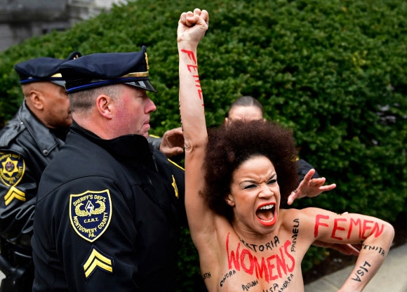 빌 코스비 ’성폭행’ 재판…법정 밖 토플리스 여성 시위