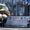 [한 컷 세상] 신문 보는 폐지 줍는 노인