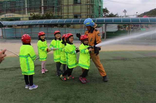 지난 4일 경남 의령군 부림초등학교 학생들이 소방관의 도움을 받아 직접 소방호스로 화재 진압을 해 보고 있다. 교육부 제공